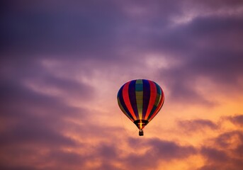 Fototapeta premium Colorful hot air balloon soaring against a dramatic sunset sky