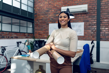 Holding blueprints confidently, architectural designer in modern office workspace, copy space