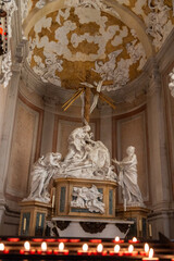 Naklejka premium Ornate Religious Altar Inside a Church An elaborately designed religious altar with intricate sculptures, featuring a central figure holding a cross. The altar is framed by a richly decorated ceiling 