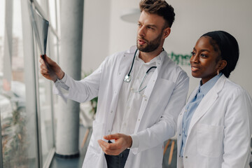 Doctors examining x ray scan discussing diagnosis in hospital