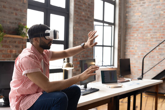 Man using VR headset in modern office, interacting with virtual environment, copy space