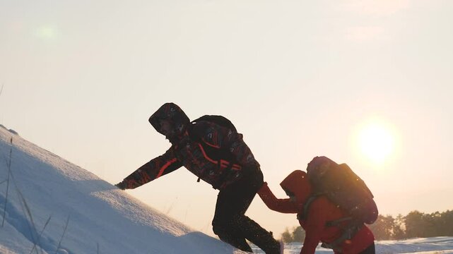 climbers go climbing the mountain forward. teamwork. travelers winter with backpacks sunset. climbing group people rise up. lifestyle love mountains adventure. active woman man teamwork give hand. sun