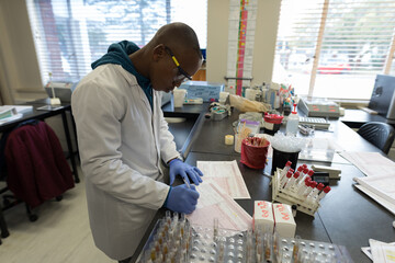 Scientist in lab coat analyzing blood samples in laboratory, focused on research