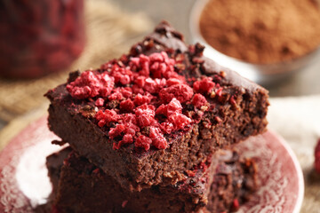 Sweet homemade gluten-free brownies made of red kidney beans, oat flakes, chocolate and freeze-dried raspberries
