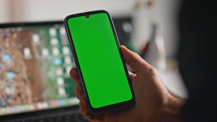 Hand holding mockup smartphone in corporate office closeup. Unknown user phone 
