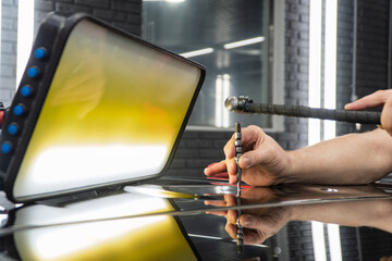 Removal of dents without painting. PDR technology for car body repair. PDR. The mechanic at the auto shop with tools to repair dents in car body. Body repair close-up.