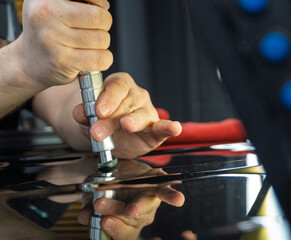 Removal of dents without painting. PDR technology for car body repair. PDR. The mechanic at the auto shop with tools to repair dents in car body. Body repair close-up.