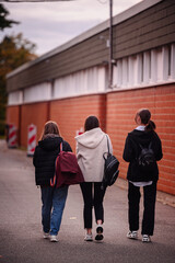Teen Girls Walking Together with Backpacks in Urban Setting