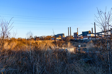View on smoke pipes of the factory at sunset