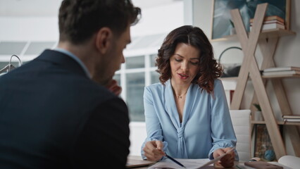 Businesswoman conducting job interview with elegant man at office desk closeup.