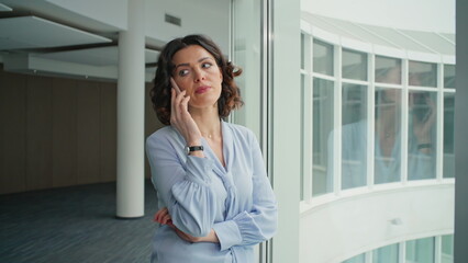 Fototapeta premium Serious lawyer consulting smartphone standing near office window closeup. 