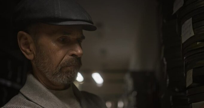 A dedicated curator is meticulously organizing various film reels in an extensive archive