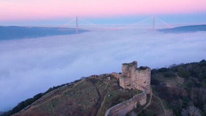 Historical Yaros Castle. Dense fog covered the entire Bosphorus like cotton candy.  YSS Bridge visible with red lights in the background. Aerial view