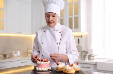 Professional pastry chef with desserts at table in kitchen