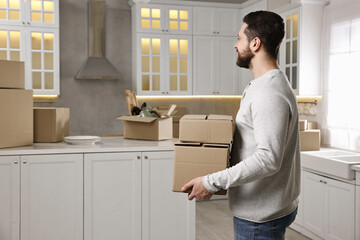 Moving day. Man with cardboard boxes in his new home