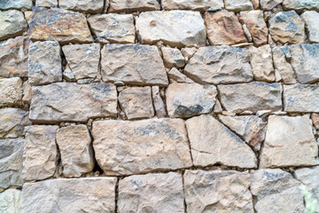 A wall made of stone with a few holes in it