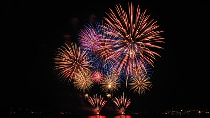 Fireworks illuminate night sky during celebration Bright colors burst over city skyline at outdoor event Represents diversity, joy, and festive spirit