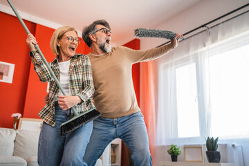 mature couple have fun while use cleaning tool like music instruments
