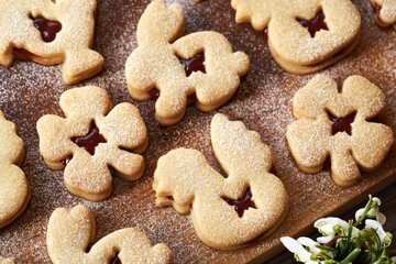 Homemade Linzer Easter cookies dusted with sugar on a wooden board