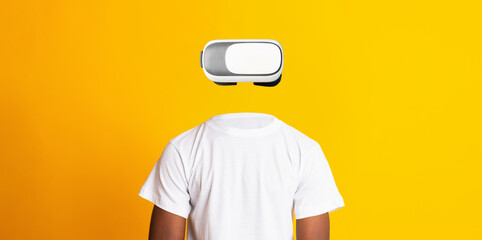 A person wearing a virtual reality headset stands against a vibrant yellow background.