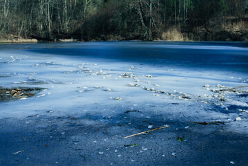 Frozen river without snow on a sunny day
