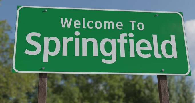 Driving By A Welcome To Springfield, Illinois Green Road Sign Against a Blue Sky and Clouds - United States Capital Series.