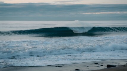 Fototapeta premium Calm ocean waves rolling onto the sandy shore during early morning light