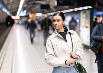 Portrait of woman at metro station waiting for a train