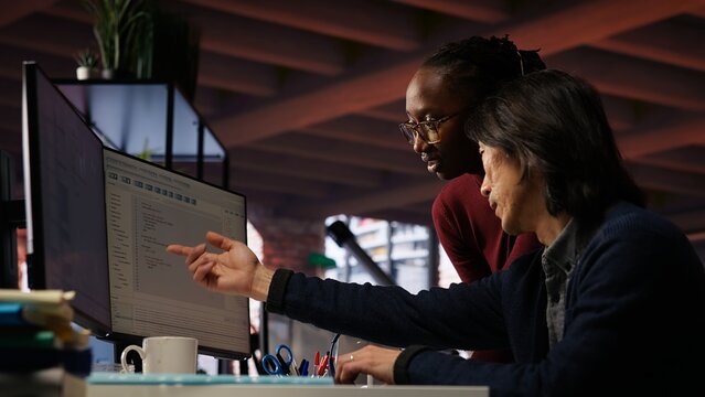 AI startup office admin asks questions to senior team leader before starting implementing machine learning. Tech venture company worker requests help from manager to fix code bugs, camera B