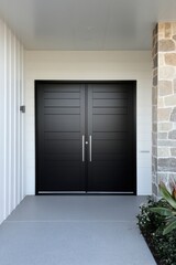Fototapeta premium Elegant modern double doors lead to a stylish entryway at a contemporary home with sleek design elements and minimalist landscaping