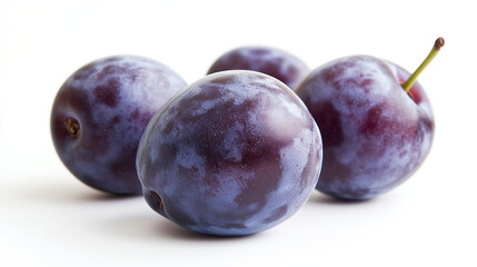 Obraz premium A close-up of ripe plums with a deep purple hue and natural waxy bloom against a white background