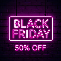 Black Friday Neon Sign with 50% Off.A vibrant pink neon sign advertising Black Friday with a 50% discount, displayed against a dark brick wall.