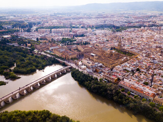 Fototapeta premium Aerial view of cityscape of Cordoba with Roman Bridge over the Guadalquivir and the Mosque-Cathedral of Cordoba