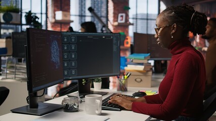 Silicon Valley venture programmer solving tasks with AI LLM chatbot using predictive technology. African american startup IT worker using PC to interact with generative model, camera A