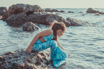 Young girl portrait in mermaid costume on the beach near sea