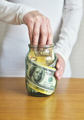 Conceptual Photo of Hand Reaching for Money in a Jar