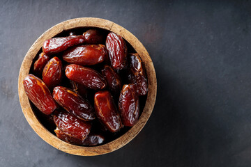 Dried Dates in Bowl on Dark Background, Healthy and Organic Middle Eastern Snack, Copy Space