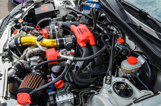 Detailed view of a Toyota Boxer car engine bay with gold-wrapped intake pipe, various hoses, and components