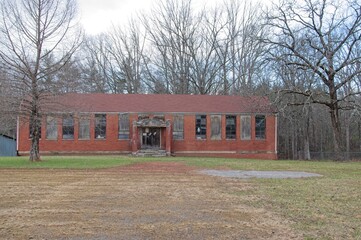 Abandoned brick school building on a cloudy day