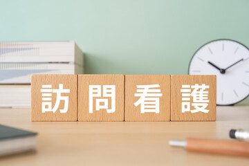 訪問看護と書かれたブロックが置かれたデスク仕事