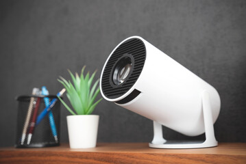 White projector with a lens on shelf