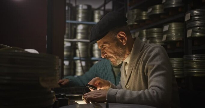Elderly Couple Examining Vintage Film Reel in Archive