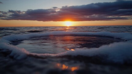 Sunset over a calm pool of water, surrounded by foamy waves