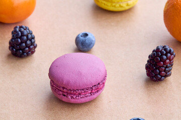 Colorful Macarons with Berries and Citrus on Plain Background