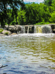 Obraz premium Waterfall Into With Large Gray Rock Into A Stream McKinney Falls