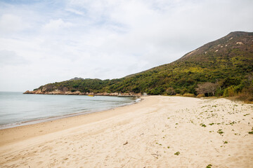 Serene Sandy Beach on Lantau Island with Coastal Hill
