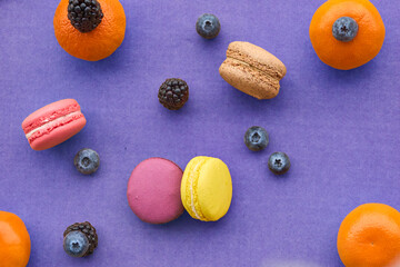 Colorful Macarons with fruit on Blue Background