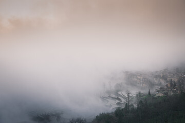 Obraz premium The village and the upper layer of the rice terraces surrounded by the dense fog