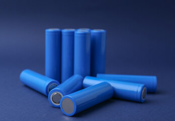 Many AA cell batteries on blue background, closeup