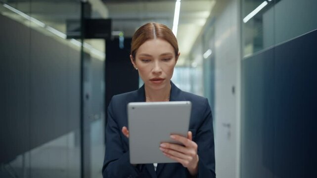 Serious businesswoman looking tablet walking hall closeup. Lady entering cabinet